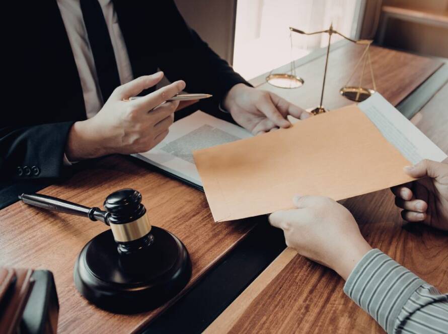 Two people exchanging documents during Illinois license reinstatement hearing process in legal office.