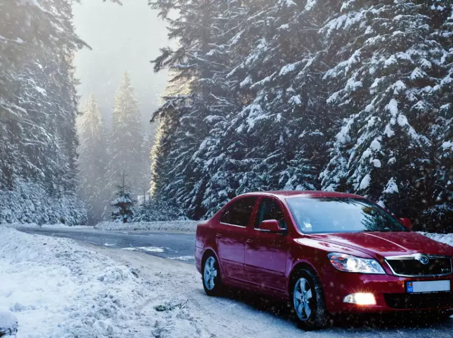 Car driving on a winter road in Illinois symbolizing a new license and restored driving privileges.